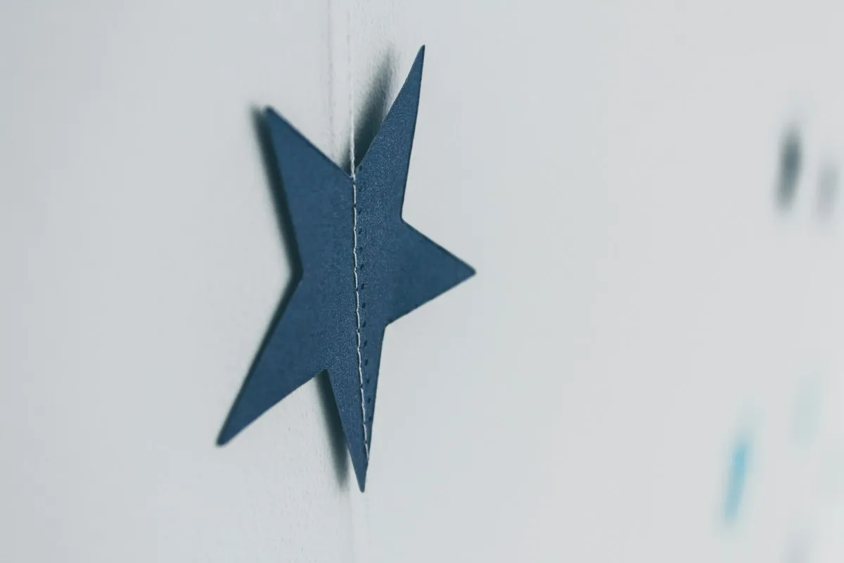 Blauer Papierstern vor hellem Hintergrund